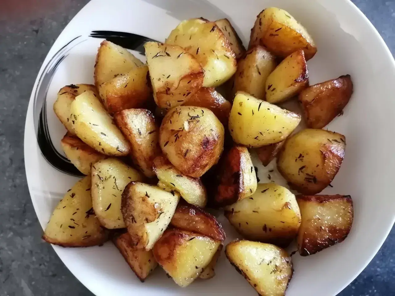Pommes de terre rôties aux herbes, parfaitement dorées, prêtes à être dégustées. Un délice facile à préparer avec le Cookeo.