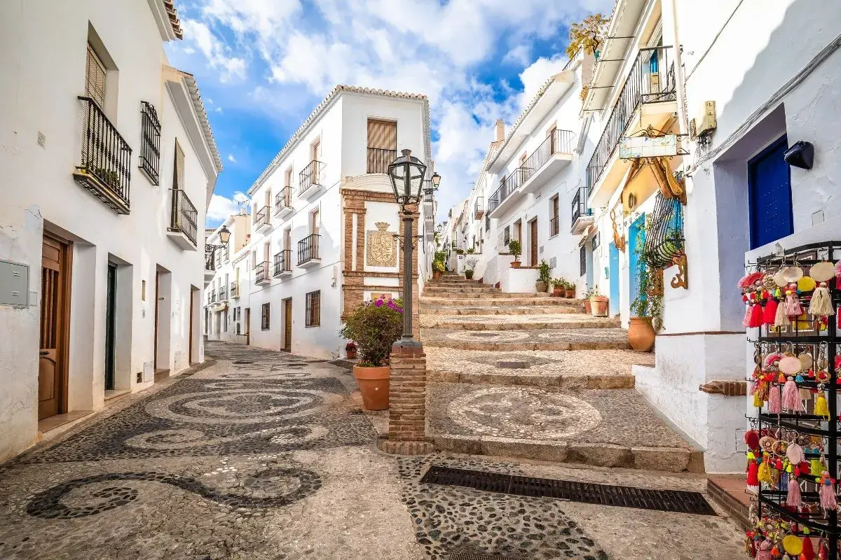 Calle empedrada con diseño de espirales, casas blancas y escalinata. Ideal para tu plan de qué ver en Andalucía en 7 días.