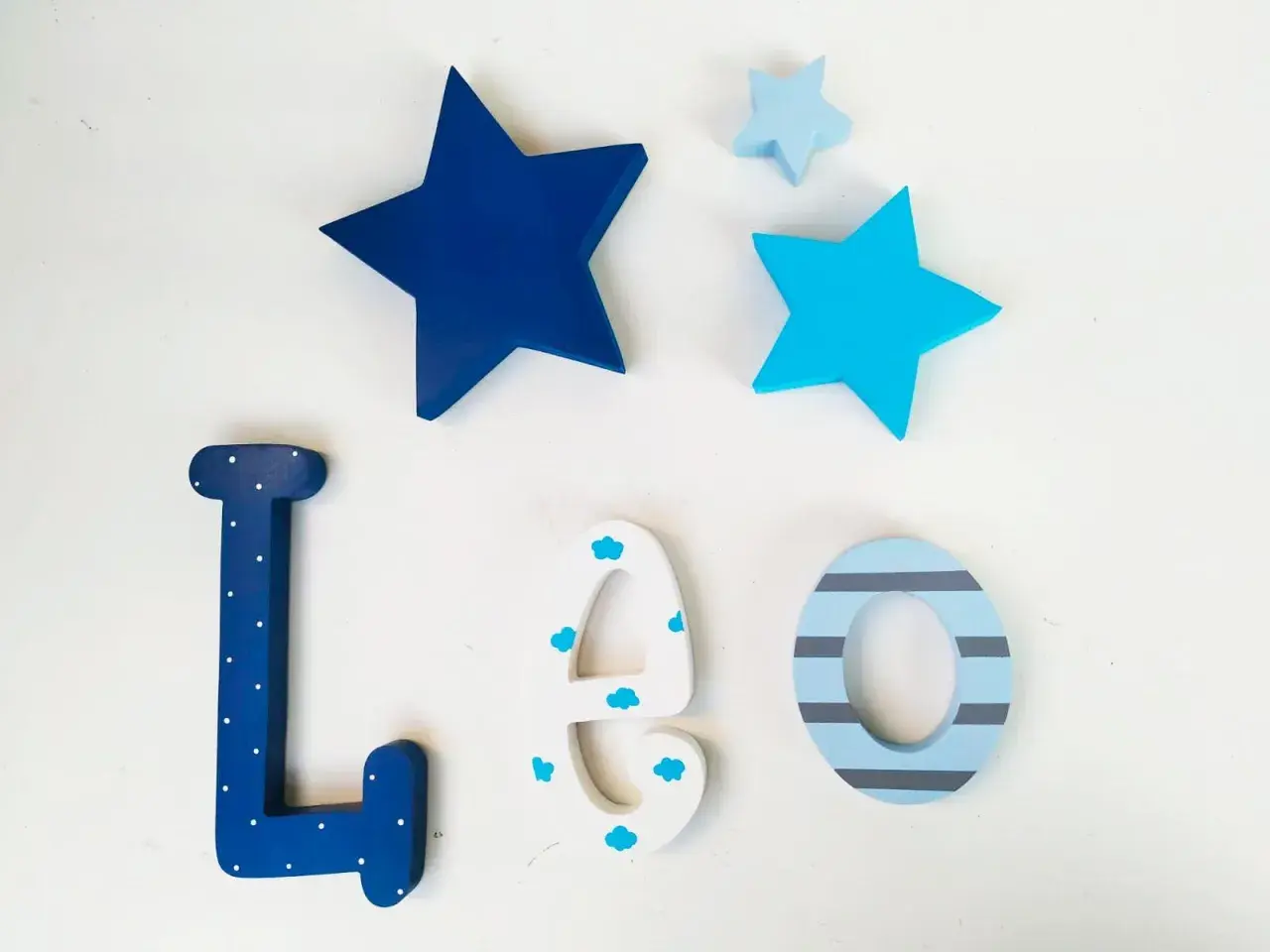 Letras infantiles de madera para decorar: L, E, O, con estrellas azules y detalles de nubes y rayas.