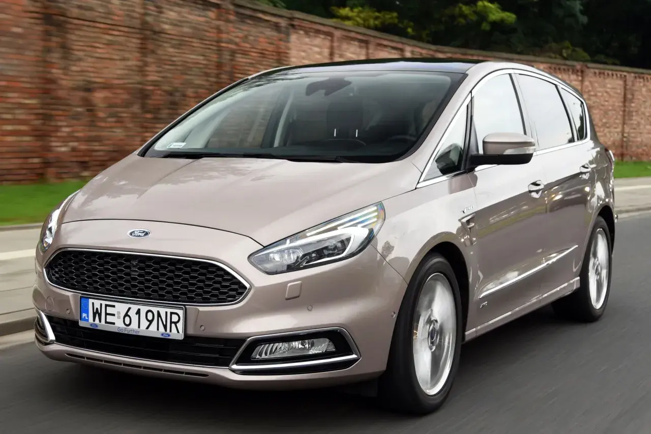 Beżowy Ford S-Max w ruchu. Wiele osób szuka ford s max opinie, ten model wygląda na komfortowy i przestronny.