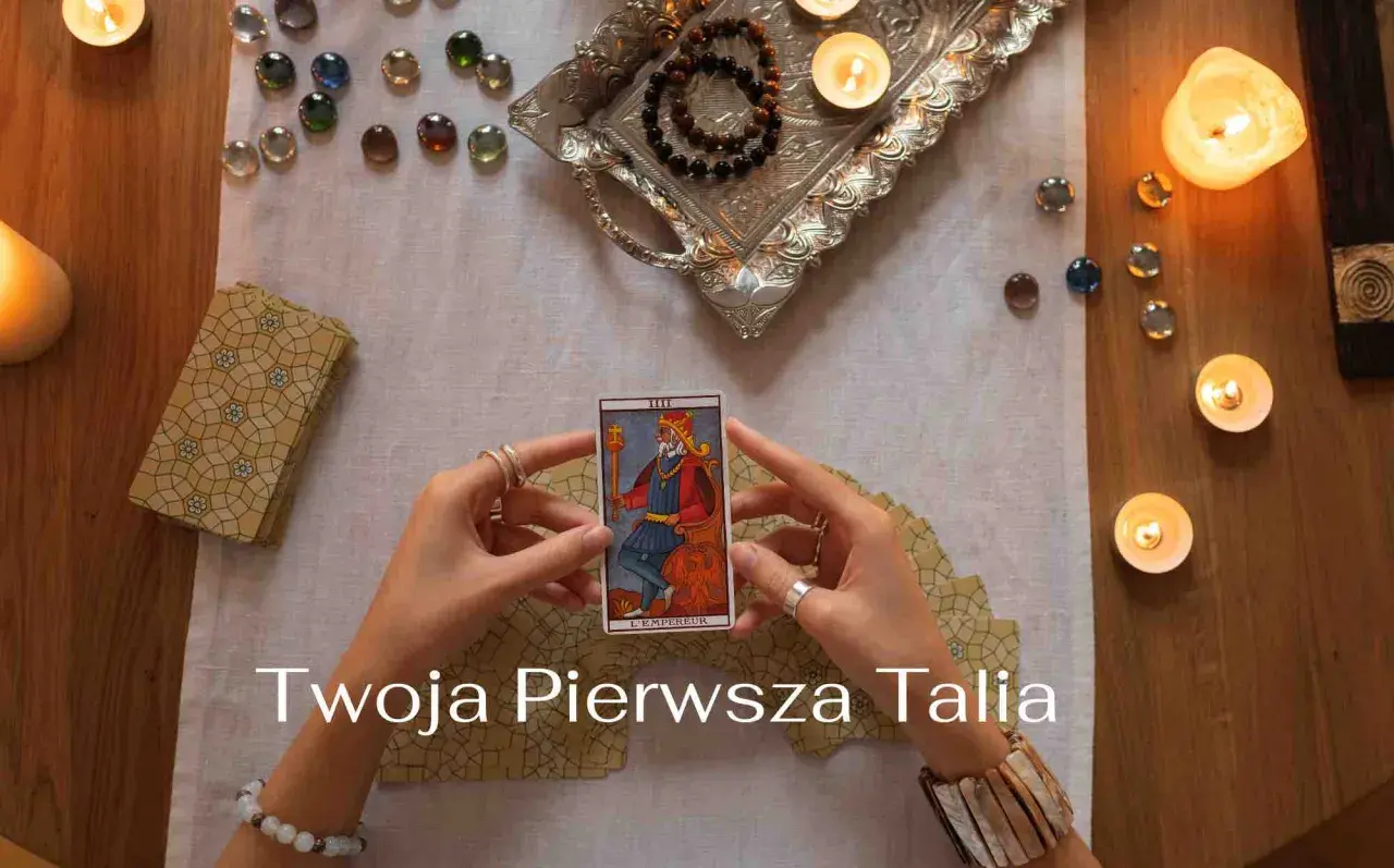Ręce trzymają kartę Tarota "Cesarz". Wokół świece, kamienie i talia kart. Idealne na początek przygody z wróżeniem, jakie karty tarota dla początkujących.