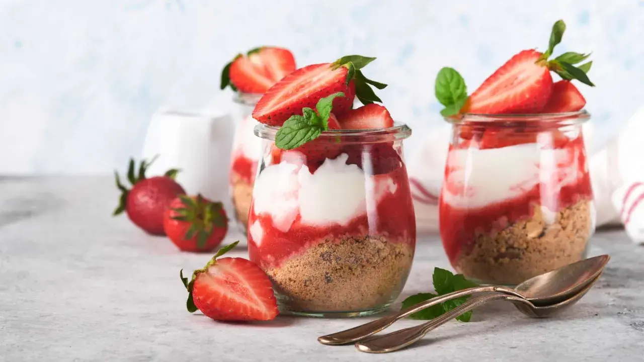Erdbeer Dessert im Glas: Schichten aus Keksbröseln, Quark und Joghurt, garniert mit frischen Erdbeeren und Minze. Ein Genuss!