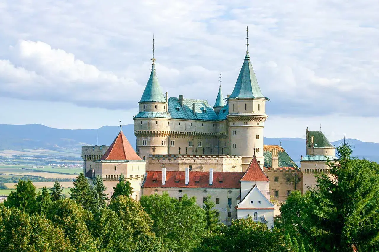 Bajkowy zamek Bojnice, jedna z najpiękniejszych słowackich atrakcji, otoczony zielenią.