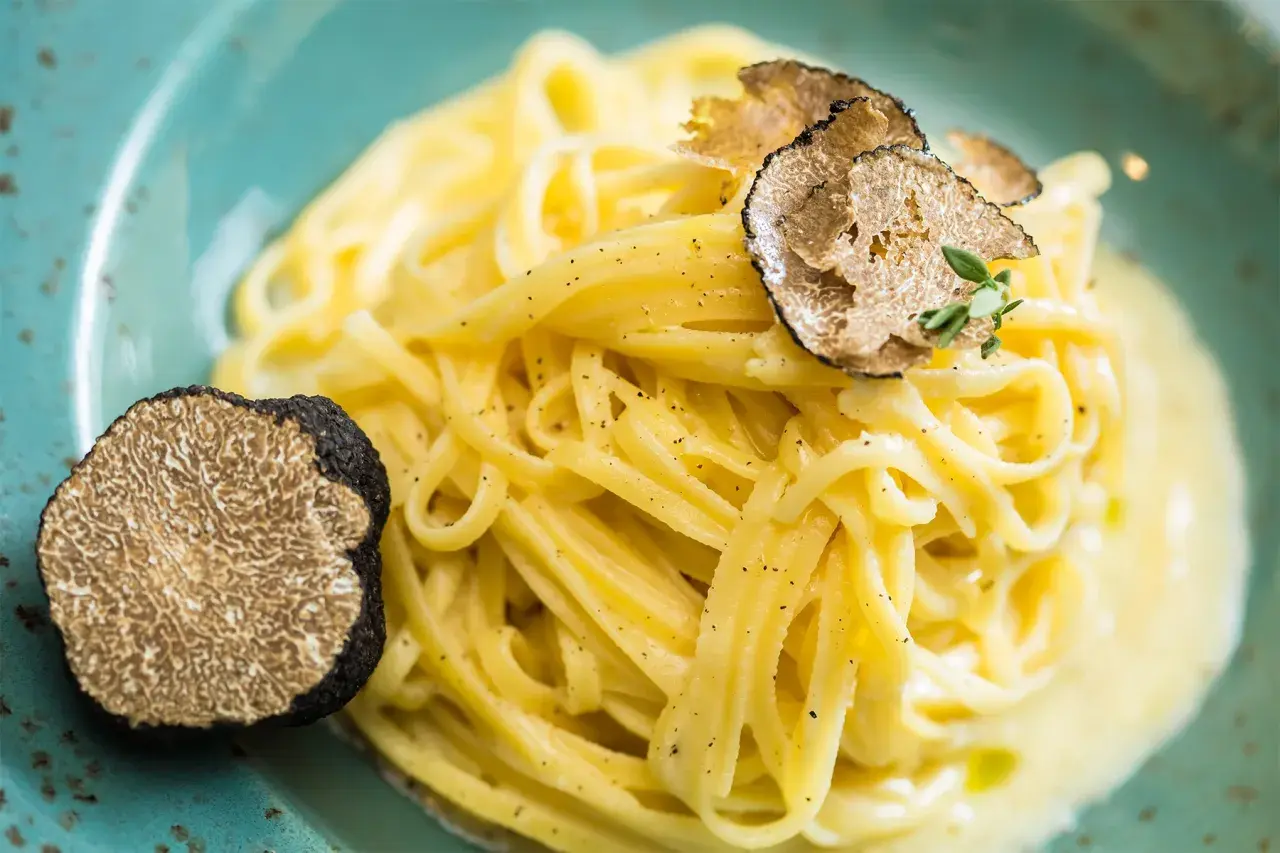 En krämig pasta med rikligt med färsk svart tryffel, en lyxig pasta tartufo.