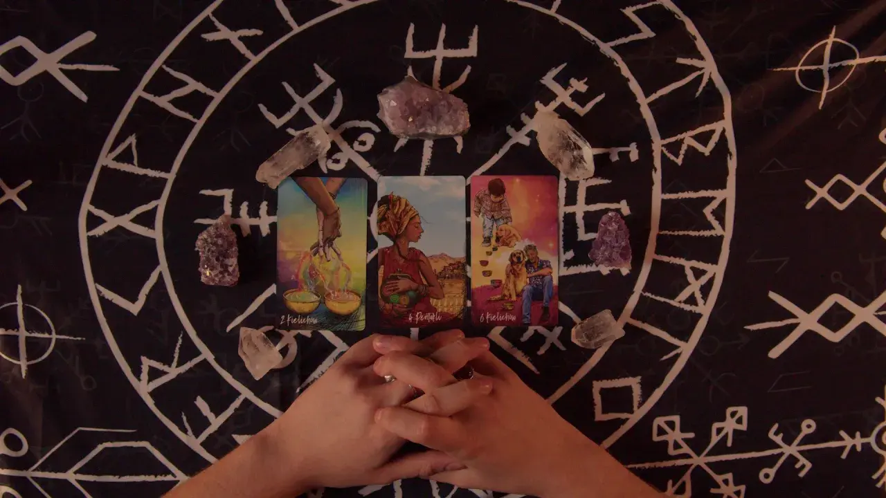 Horoskop miesięczny Lew Tarot: karty i kryształy na tle runicznym.