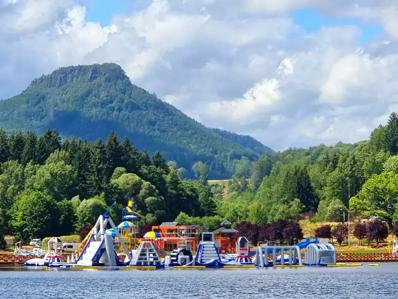 Kolorowy park wodny na **zalewie radkowskim** z górami w tle.
