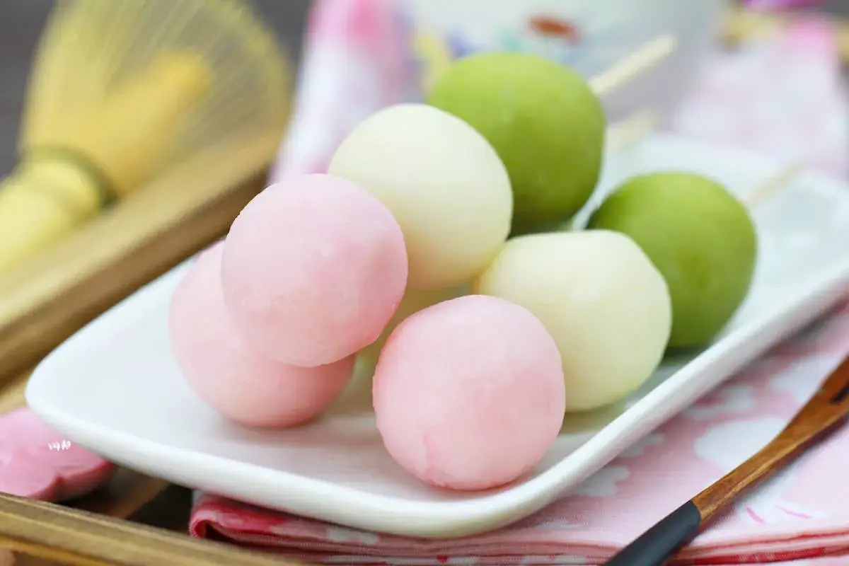Bunte Hanami Dango auf einem Teller, bereit zum Genießen.