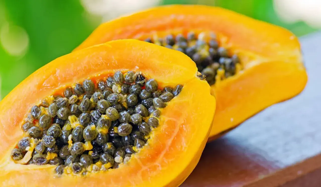 Zwei Hälften einer reifen Papaya mit vielen schwarzen Samen. Die Papaya ist bekannt für ihre verdauungsfördernde Papain-Wirkung.