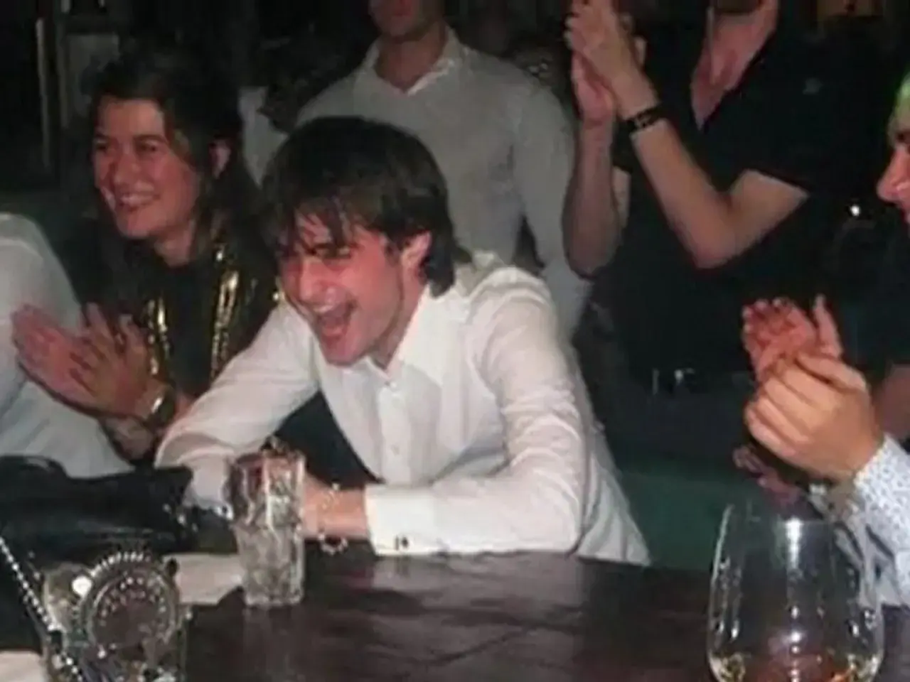 Daniel Radcliffe śmieje się głośno, otoczony przyjaciółmi. W tle widać ludzi klaszczących. Nie ma tu mowy o narkotykach.