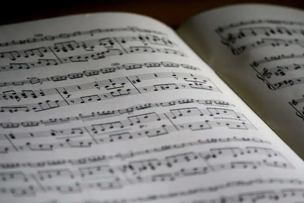Otwarta księga z nutami, idealna do nauki, jak czytać nuty. Linie i symbole tworzą melodię.