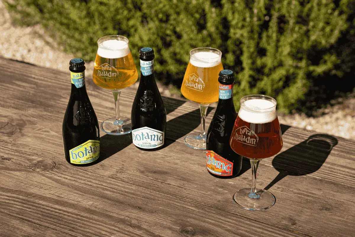 Bottiglie e bicchieri di birra analcolica Baladin su un tavolo di legno. La birra fa male, ma questa è analcolica!