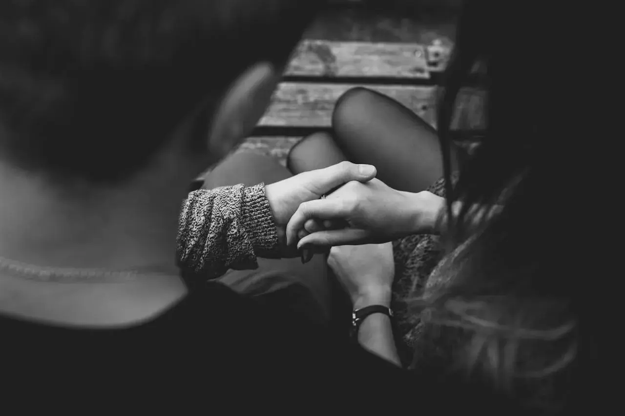 Manos entrelazadas, ¿es amor o dependencia emocional? La conexión se siente intensa en esta imagen en blanco y negro.