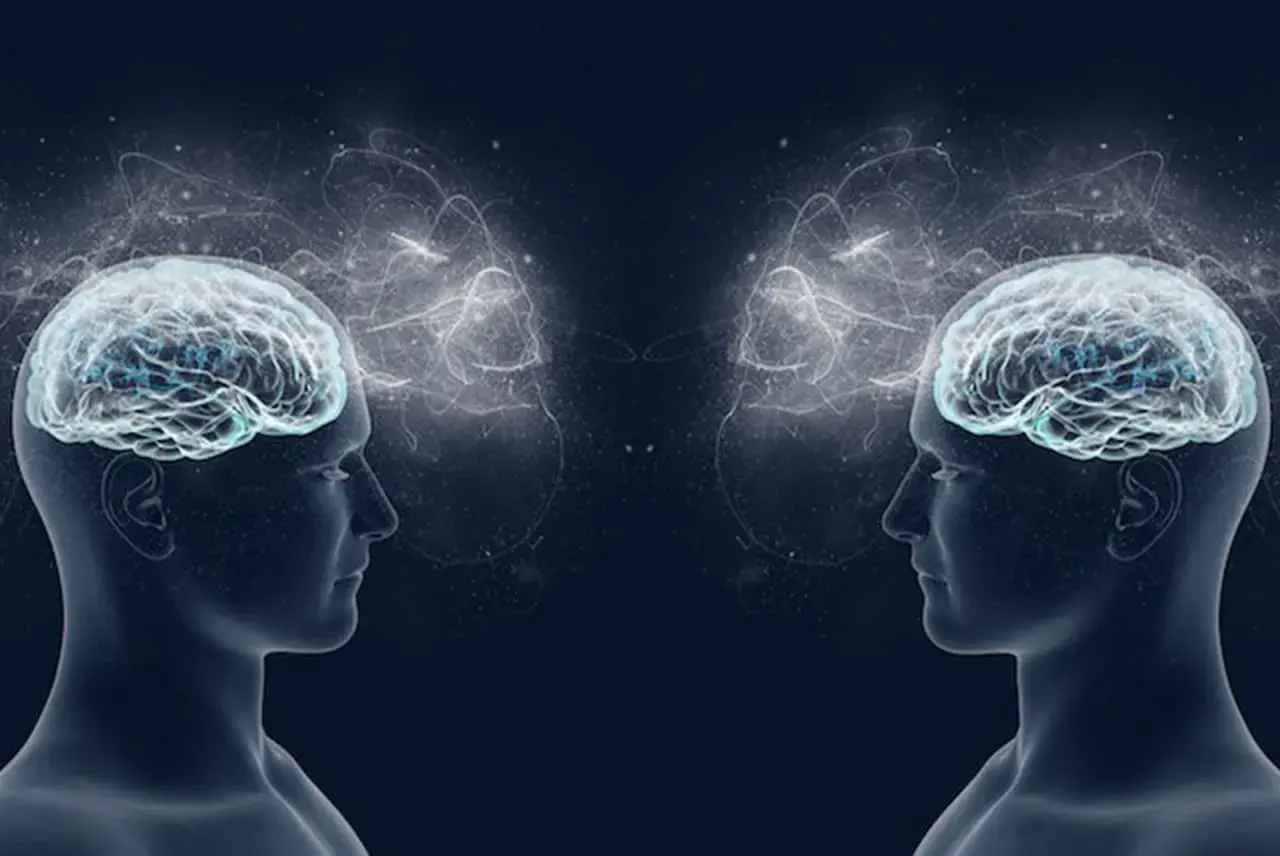 Due profili umani speculari con cervelli luminosi e connessioni eteree, che evocano i neuroni specchio e la comprensione empatica.