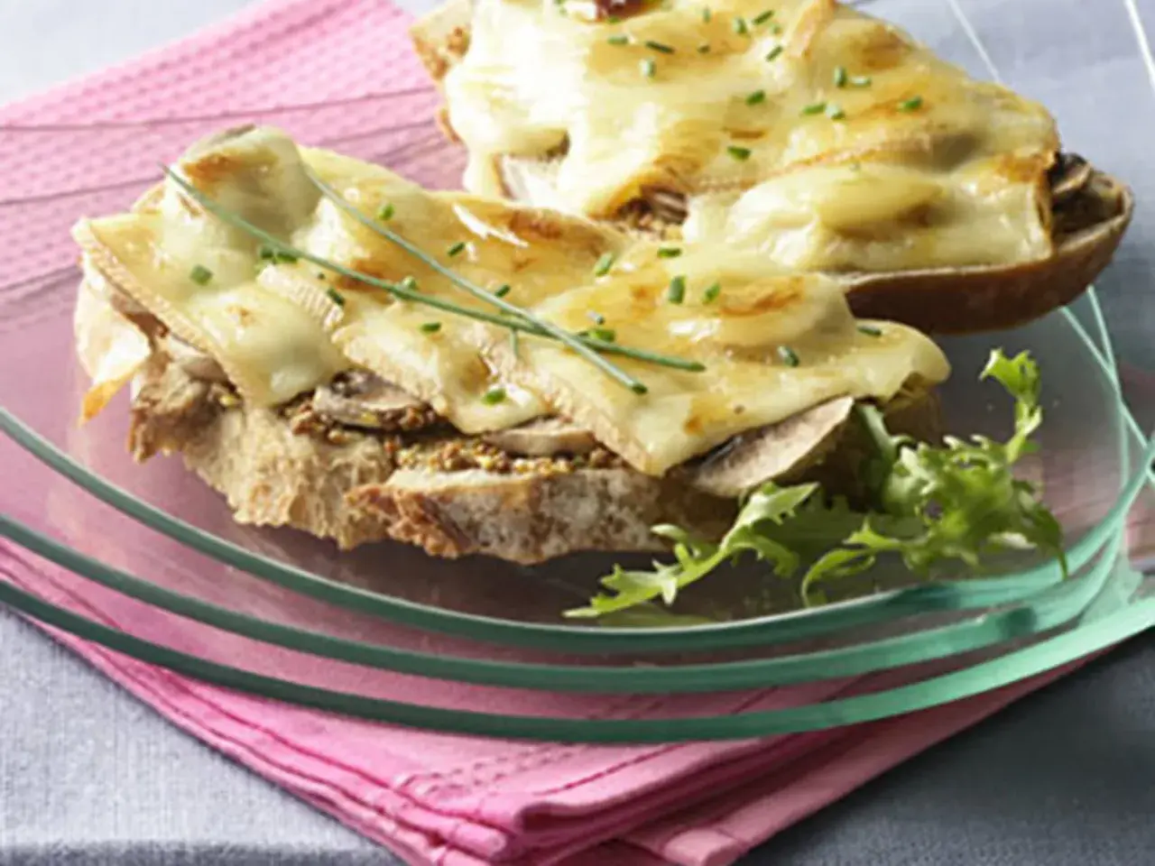 Tartines gourmandes avec une généreuse croute de fromage fondue, garnies de champignons et de ciboulette.