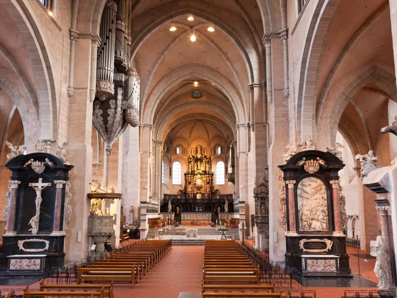Innenansicht des Trierer Doms mit Orgel, Bänken und dem Hochaltar. Die dominformation trier ist beeindruckend.