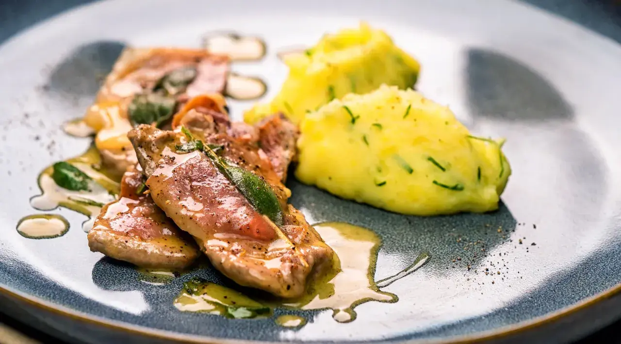 Saltimbocca: Kalbfleisch mit Salbei und Schinken, serviert mit Kartoffelpüree. Ein Klassiker, der zeigt, was Saltimbocca ist.
