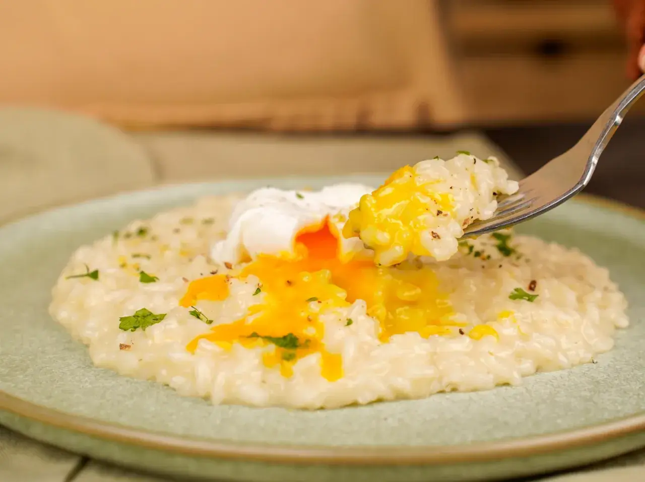 Un cremoso risotto con un uovo in camicia, il cui tuorlo dorato si riversa sul riso. Un piatto invitante e gustoso.