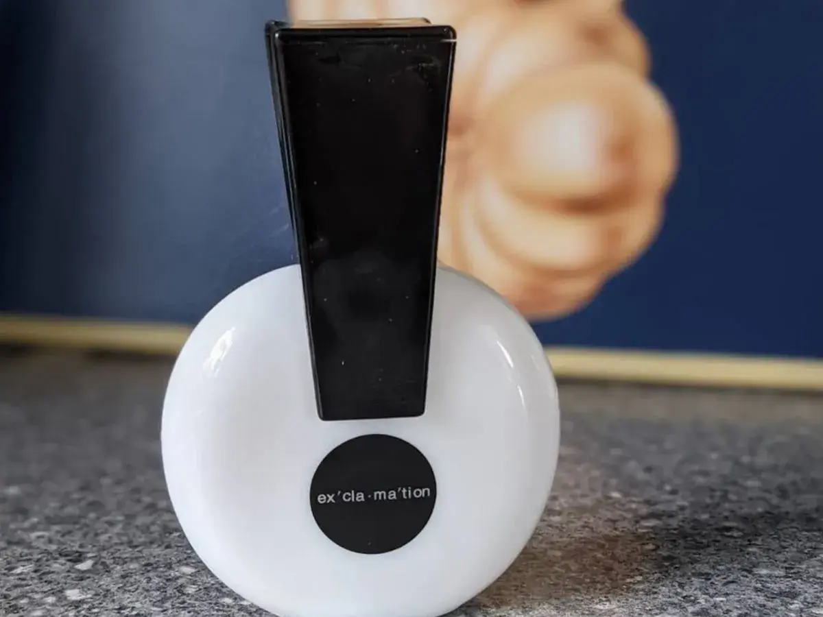 Perfumy Exclamation z lat 90. gdzie kupić? Biały flakonik z czarnym korkiem i napisem "ex'cla-ma'tion".