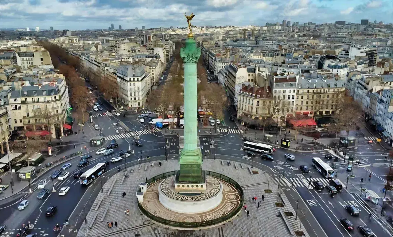 Vue aérienne de la colonne de Juillet sur la place de la Bastille, avec le trafic parisien animé autour.