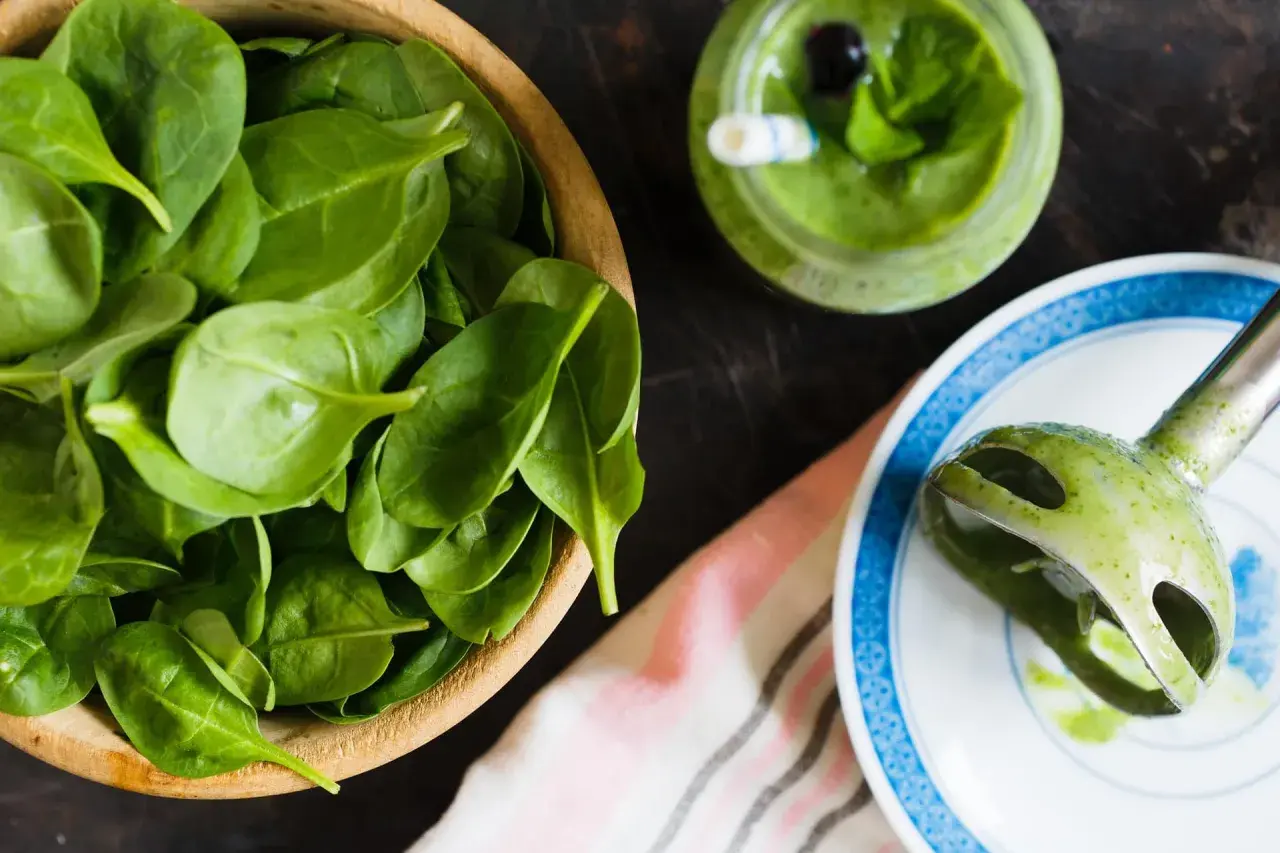 Świeży szpinak w misce, zielony koktajl i blender ręczny. Czy szpinak jest zdrowy? Tak, to superfood!