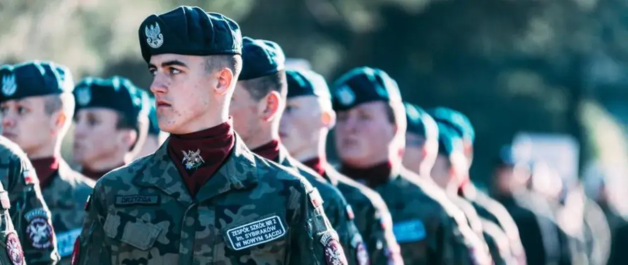 Młodzi żołnierze w mundurach, gotowi do służby. Zastanawiają się, jaki stopień wojskowy po szkole średniej osiągną.