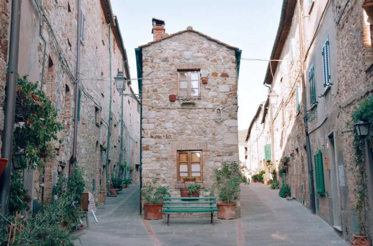 Un vicolo suggestivo con case in pietra e piante. Un invito a scoprire cosa vedere a Cecina, tra scorci autentici.