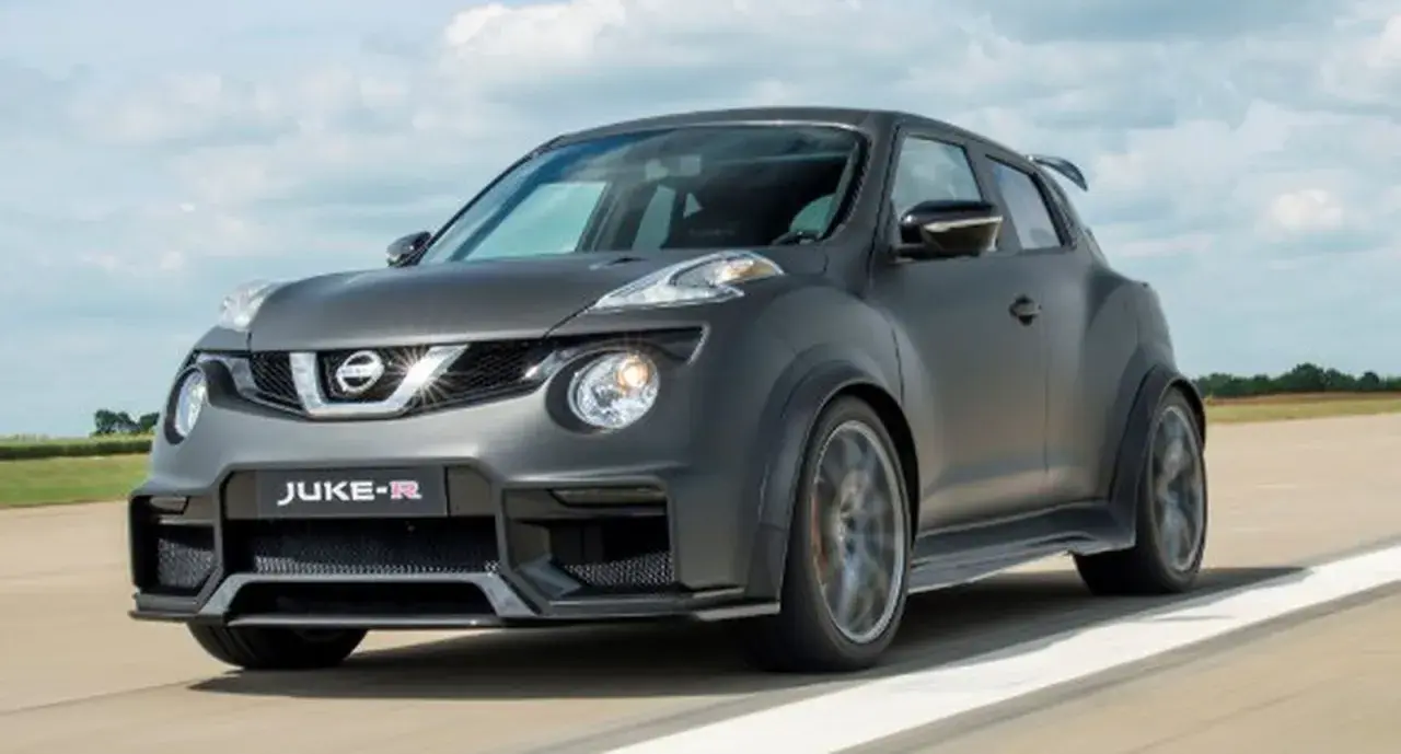 Nissan Juke-R gris oscuro, con alerón trasero y llantas deportivas, circulando por una pista.