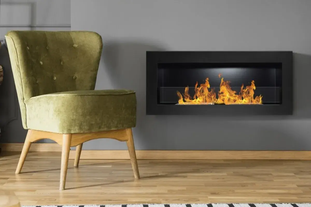 Sillón verde junto a una chimenea moderna con llamas danzantes. El humo de la chimenea crea un ambiente acogedor.