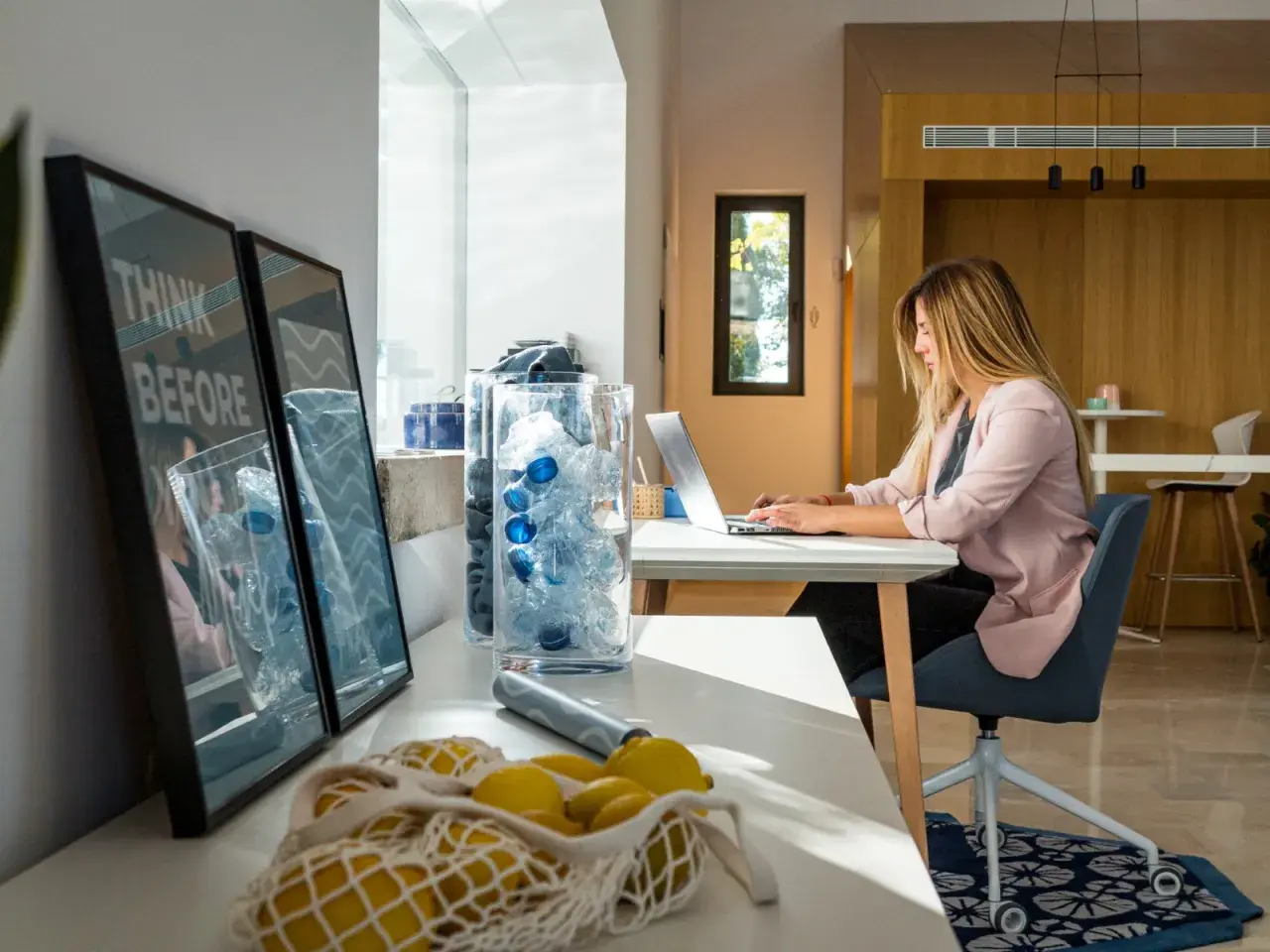 Mujer trabajando en portátil con luz natural. La luz que entra por la ventana es ideal para la vista.