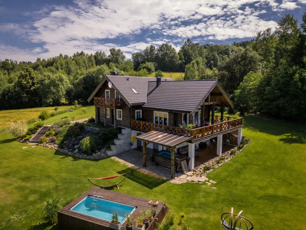 Drewniany domek w górach z basenem i hamakiem. Idealne miejsce na tanie domki w górach, gdzie można odpocząć wśród zieleni.