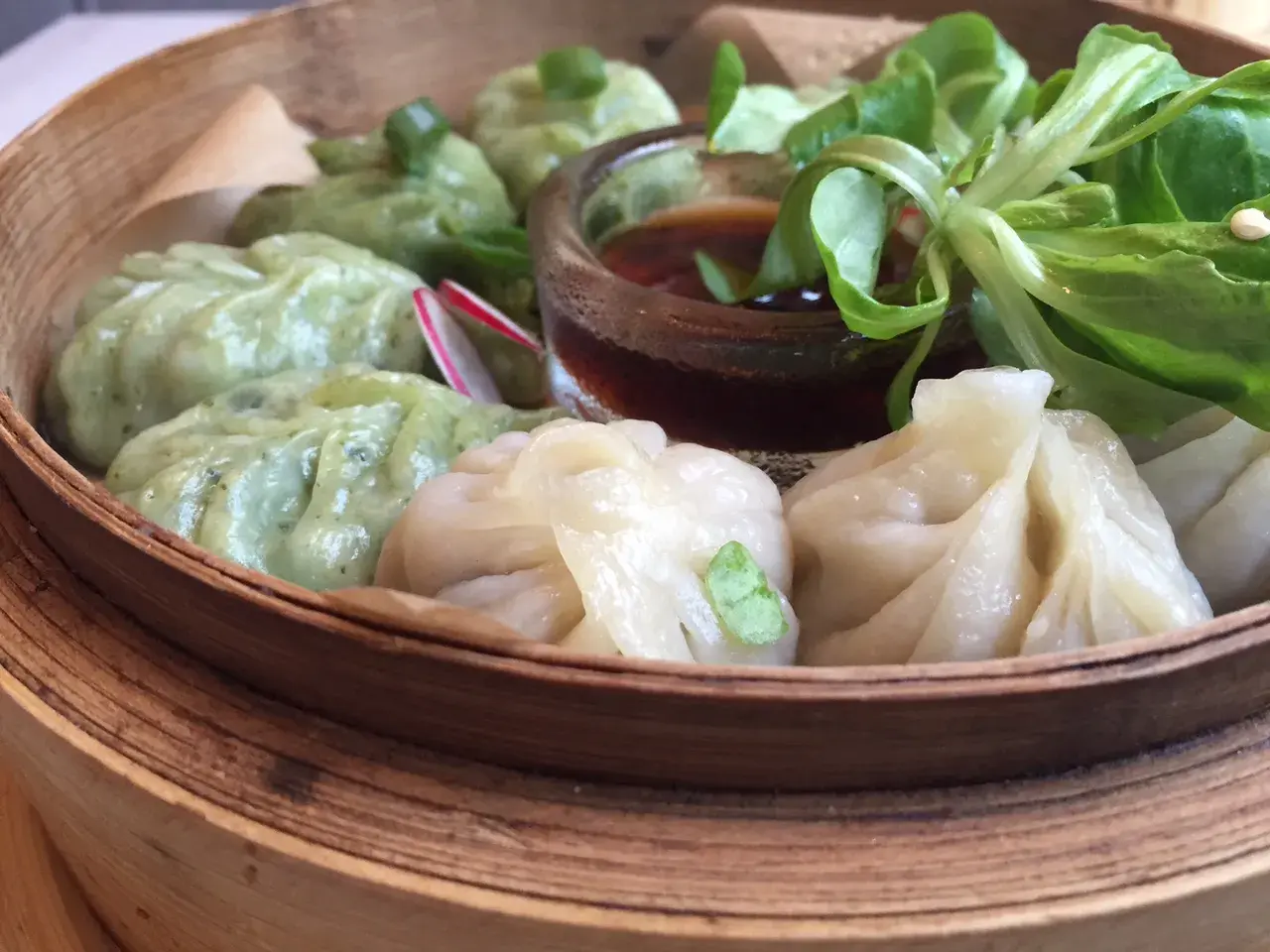 Parowóz z dim sum: zielone i białe pierożki z sosem i sałatką.