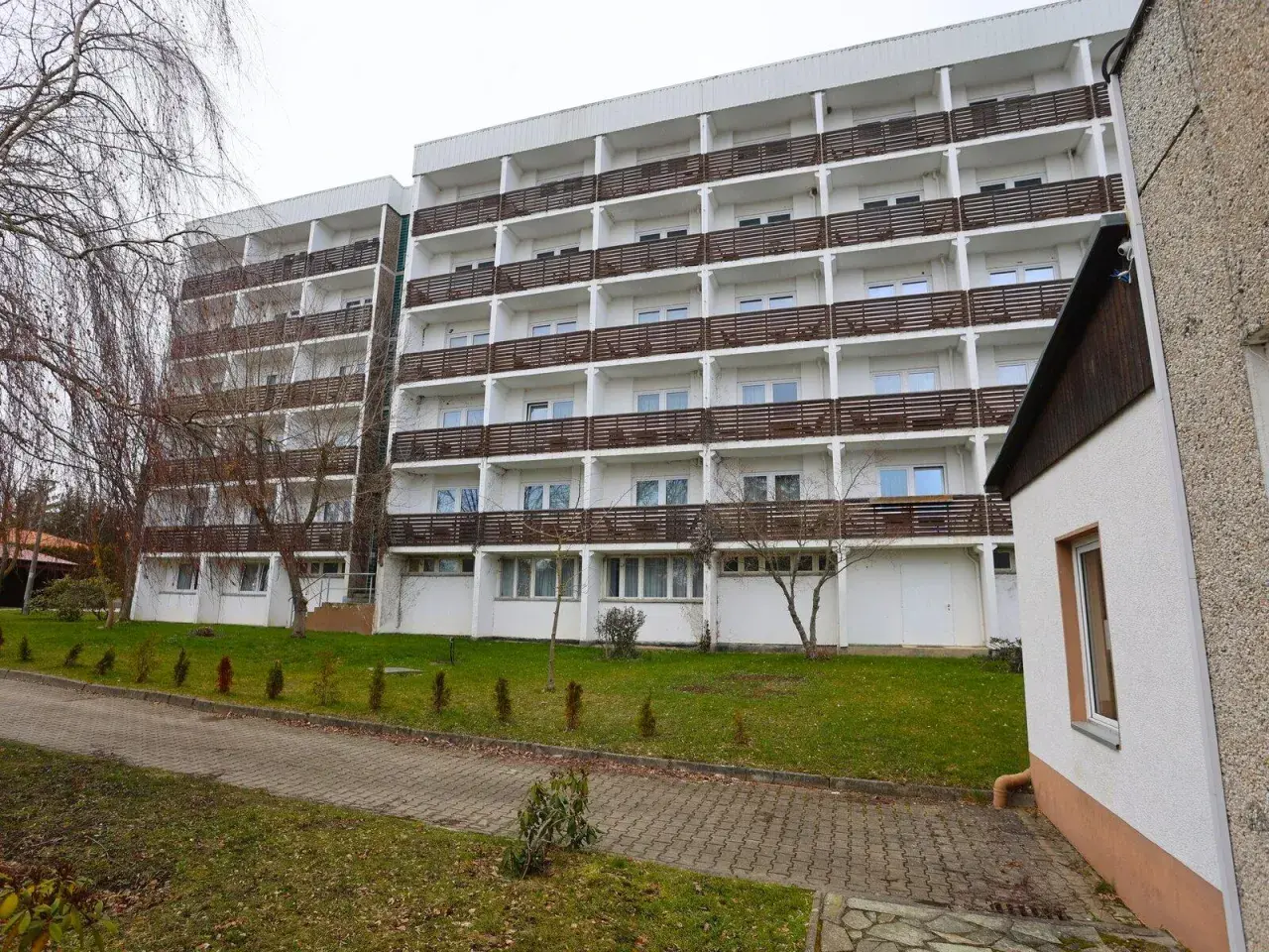 Das Carea Harz Hotel Allrode, ein großes Gebäude mit vielen Balkonen, liegt inmitten einer grünen Anlage.