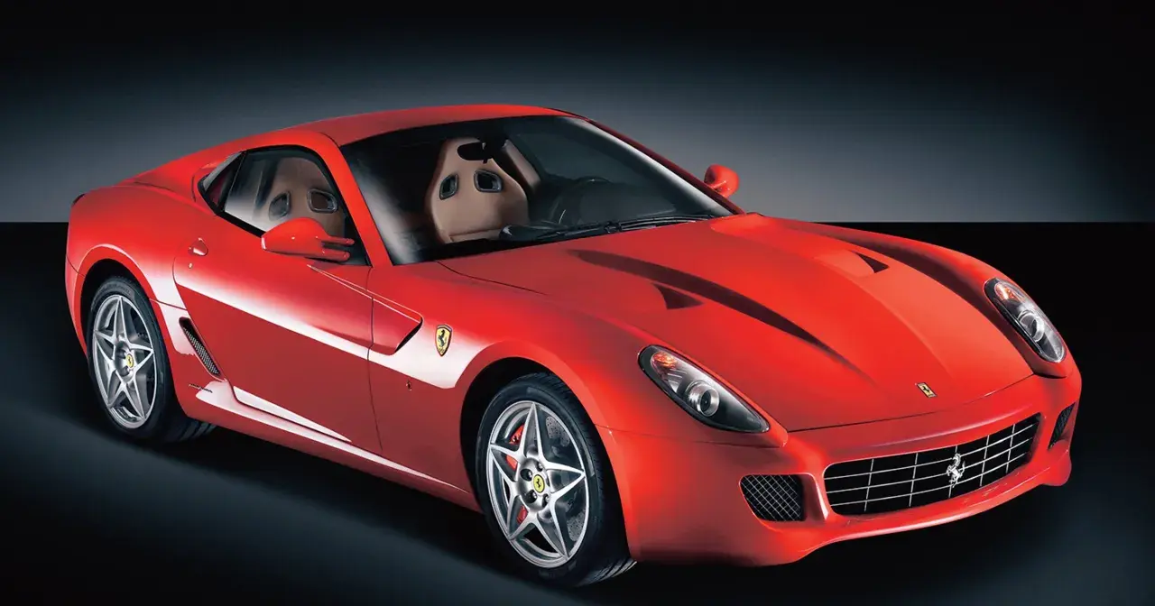 Czerwone Ferrari 599 z beżowym wnętrzem, sportowymi fotelami i felgami w kształcie gwiazdy.