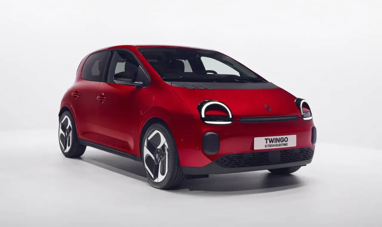 Czerwony Renault Twingo Electric z okrągłymi światłami dziennymi i czarnymi felgami, gotowy do miejskiej jazdy.