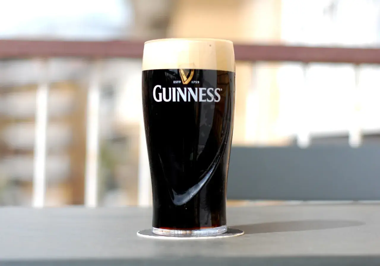 Un bicchiere di birra scura irlandese Guinness, con la sua iconica schiuma cremosa, pronto per essere gustato.