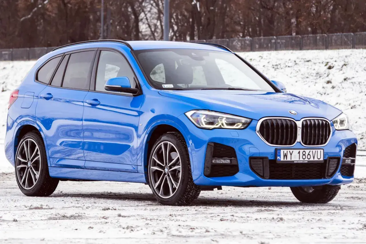 Błękitne BMW X1 2025 na śniegu, gotowe na zimowe wyzwania.