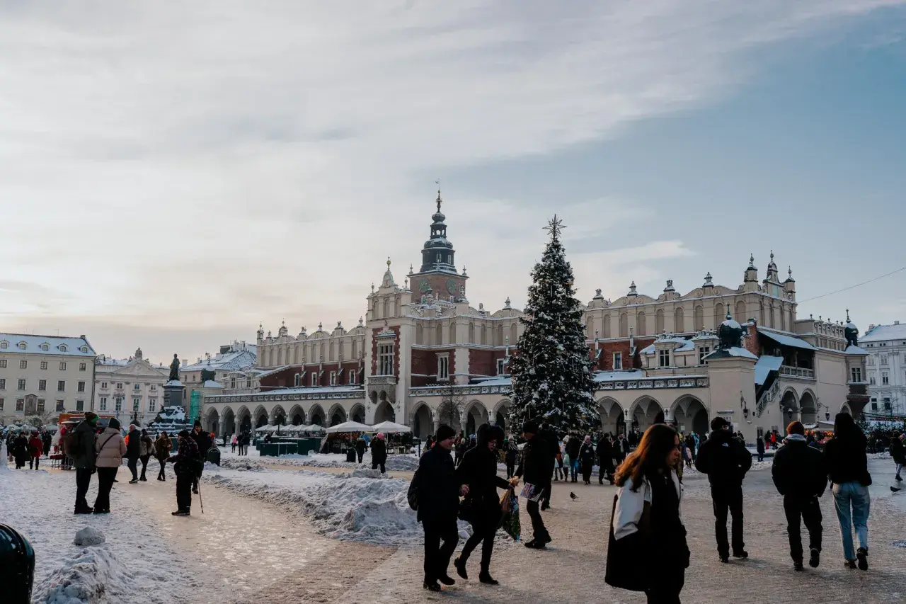 Zimowy Rynek Główny w Krakowie z choinką i ludźmi. Idealne miejsce na darmowe wydarzenia w Krakowie.
