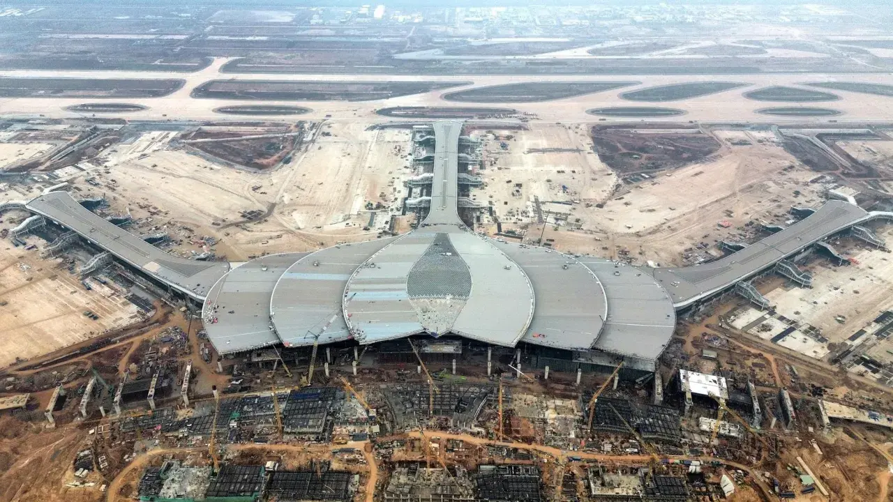 Budowa jednego z nowych lotnisk w Wietnamie. Futurystyczny terminal w kształcie kwiatu lotosu i pasy startowe w tle.