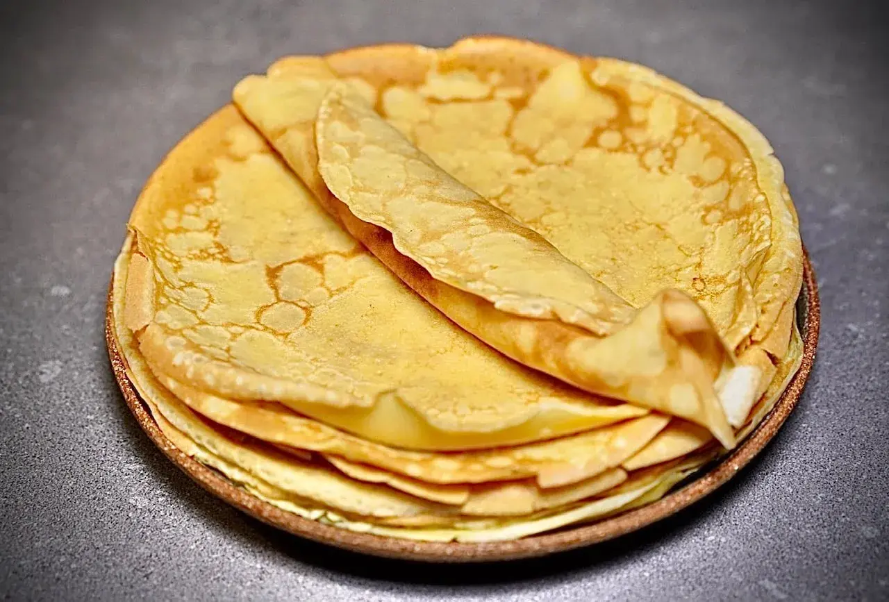 Pile de crêpes dorées et moelleuses, parfaites pour une recette facile.