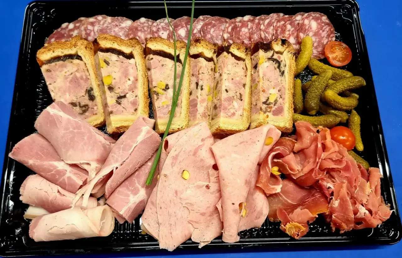 Plateau de charcuterie : terrines, jambon, saucisson, cornichons et tomates cerises. Idéal pour savoir que mettre dans un plateau de charcuterie.