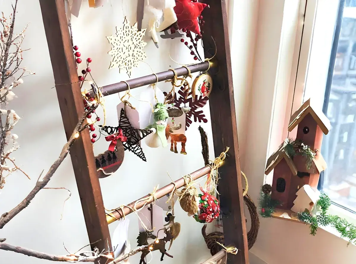 Eine Leiter weihnachtlich dekorieren: Sterne, Schneeflocken, Rentiere und Lichterketten schmücken die Sprossen.