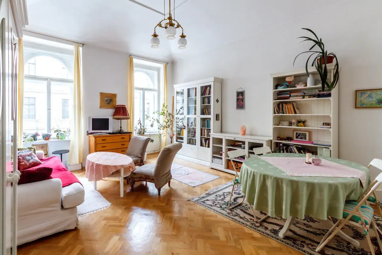 Przytulny salon z kanapą, dwoma fotelami, regałami i stołami. Idealne miejsce na umowa na czas nieoznaczony.