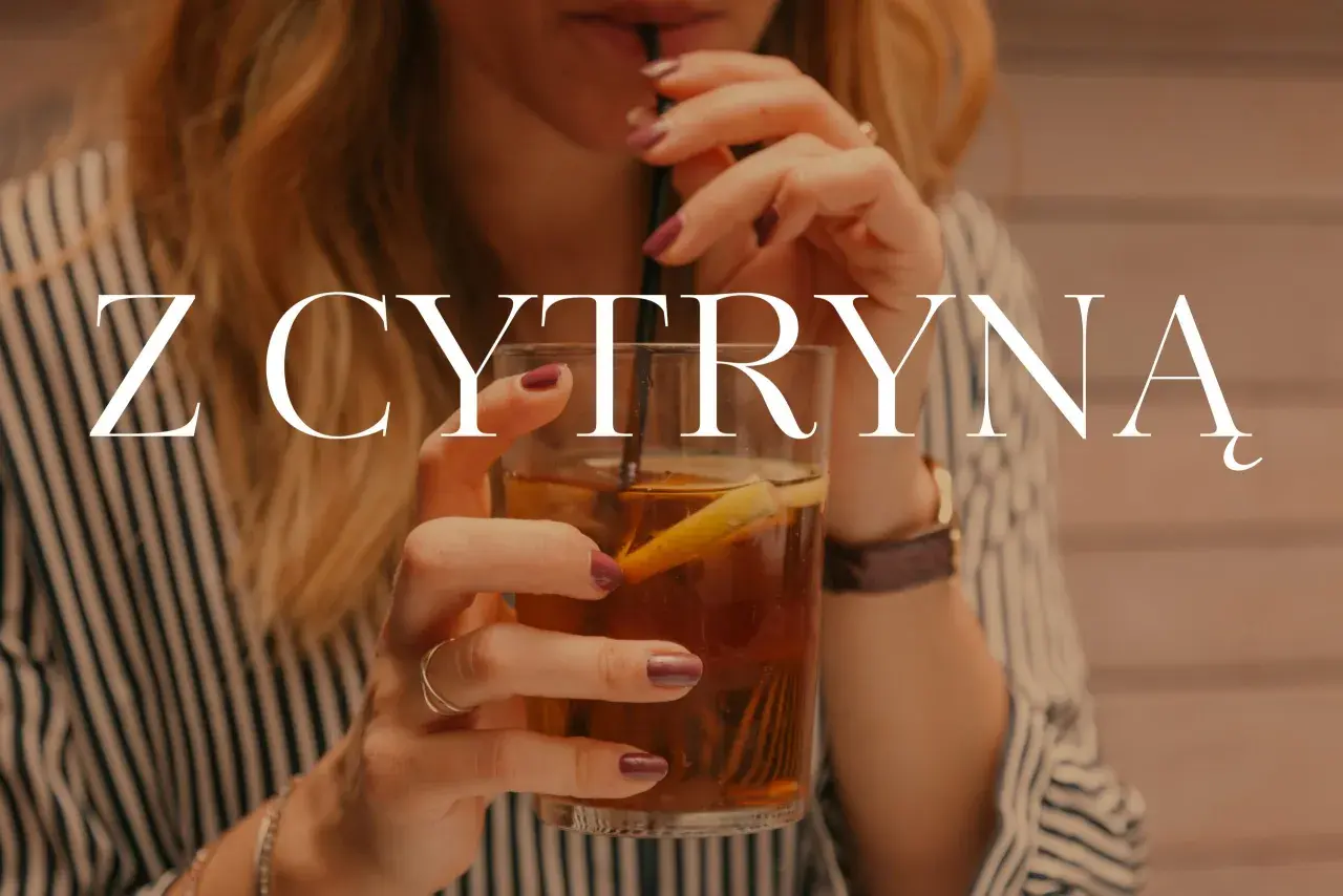 Kobieta pije herbatę z cytryną. Czy herbata z cytryną jest szkodliwa? Napój w szklance z lodem i plasterkiem cytryny.