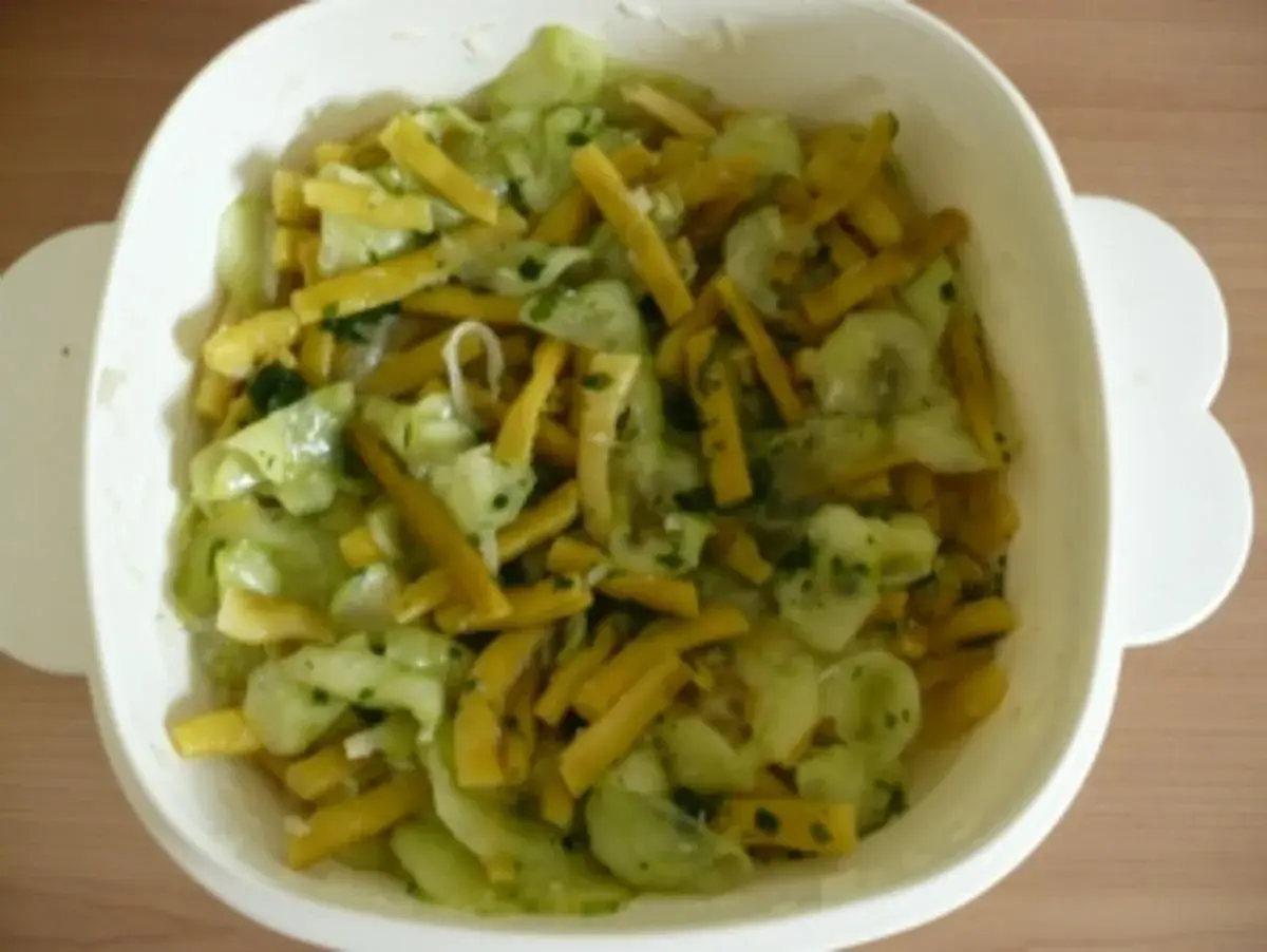 Frischer Bohnen Gurken Salat mit Kräutern in einer weißen Schüssel.
