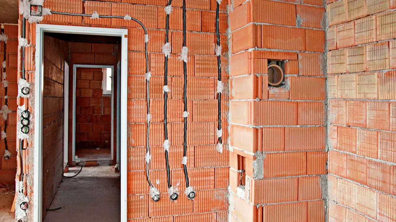 Nowe przewody elektryczne prowadzone po ścianie z pustaków ceramicznych, to nowoczesna wymiana instalacji elektrycznej bez kucia.