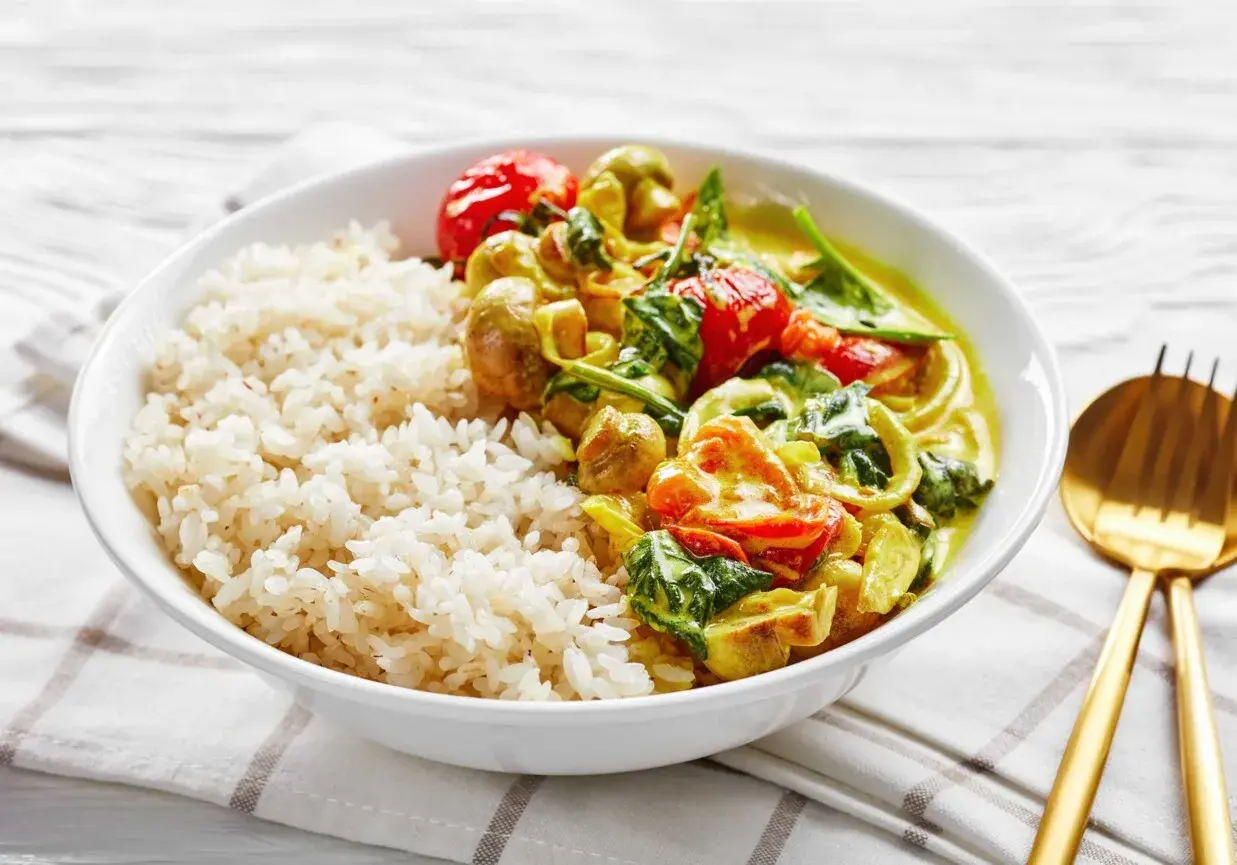 Pyszne dania na ciepło bez mięsa: ryż z aromatycznym curry warzywnym, pomidorkami i szpinakiem.