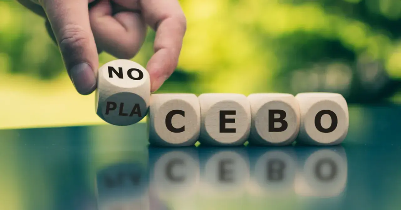 Palec odwraca kostkę z napisem "NO" na "PLACEBO", pokazując, czym jest efekt nocebo.