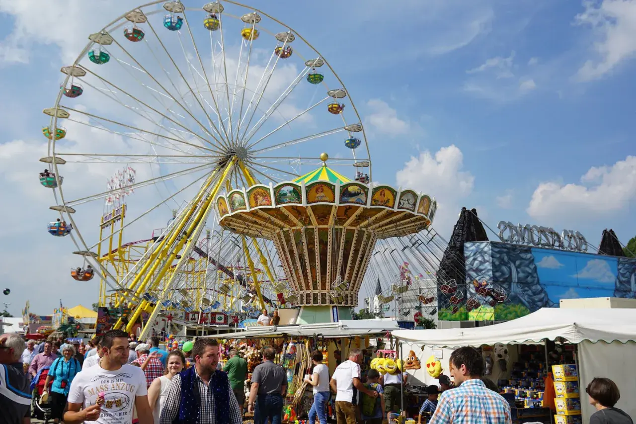 Buntes Treiben auf dem **Karpfhamer Fest** mit Riesenrad, Kettenkarussell und vielen Besuchern.