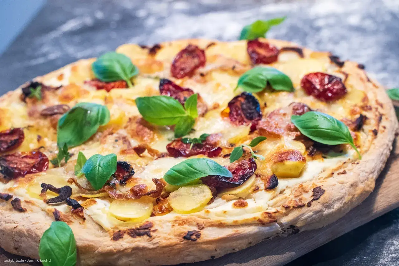 Leckeres Pizza Bianca Rezept mit Kartoffeln, Tomaten und frischem Basilikum.