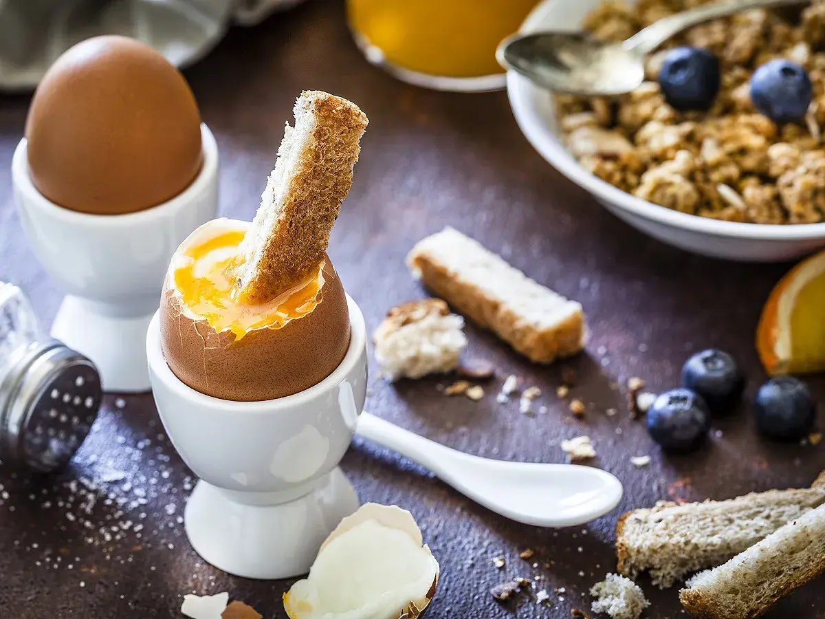 Un œuf cuit à la coque, prêt à être dégusté avec des mouillettes. Un petit-déjeuner gourmand et réconfortant.